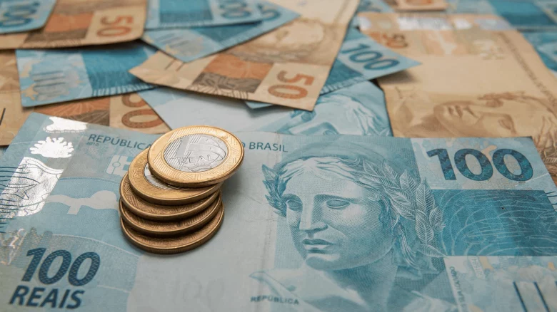 Notas de real sobre a mesa, simbolizando recebimento de valores indevidos e possível devolução ao órgão pagador.