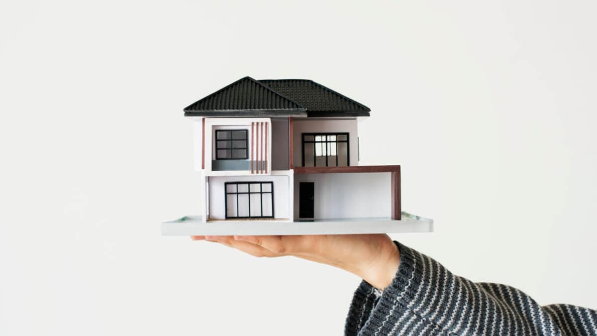 Imagem de uma mão segurando uma miniatura de uma casa para simbolizar o que é usucapião