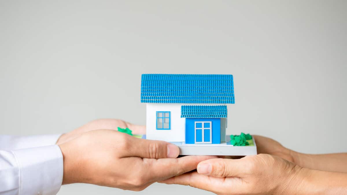 Imagem de duas mãos segurando uma miniatura de uma casa para simbolizar reintegração de posse