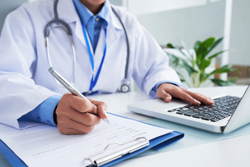 Imagem de um médico mexendo no computador para simbolizar plano de saúde cobre abdominoplastia