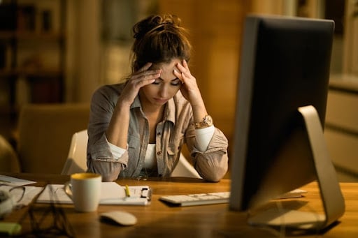 uma mulher exausta no trabalho para simbolizar burnout e aposentadoria