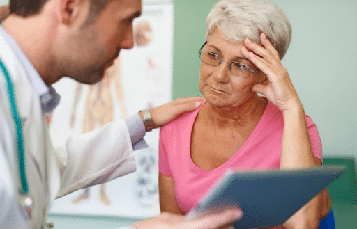 Imagem de um médico conversando com uma senhora paciente para simbolizar o que é erro médico