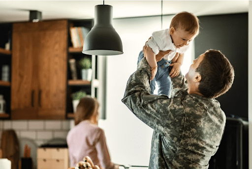 Imagem de um militar com seu filho no colo para simbolizar serviço militar temporário