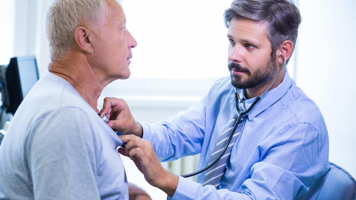 Imagem de um médico ouvindo o coração de um paciente idoso para simbolizar a cardiopatia grave