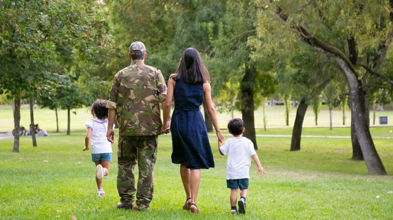 Imagem de um militar de costas com sua familia, uma mulher e dois filhos, para simbolizar o auxílio-funeral