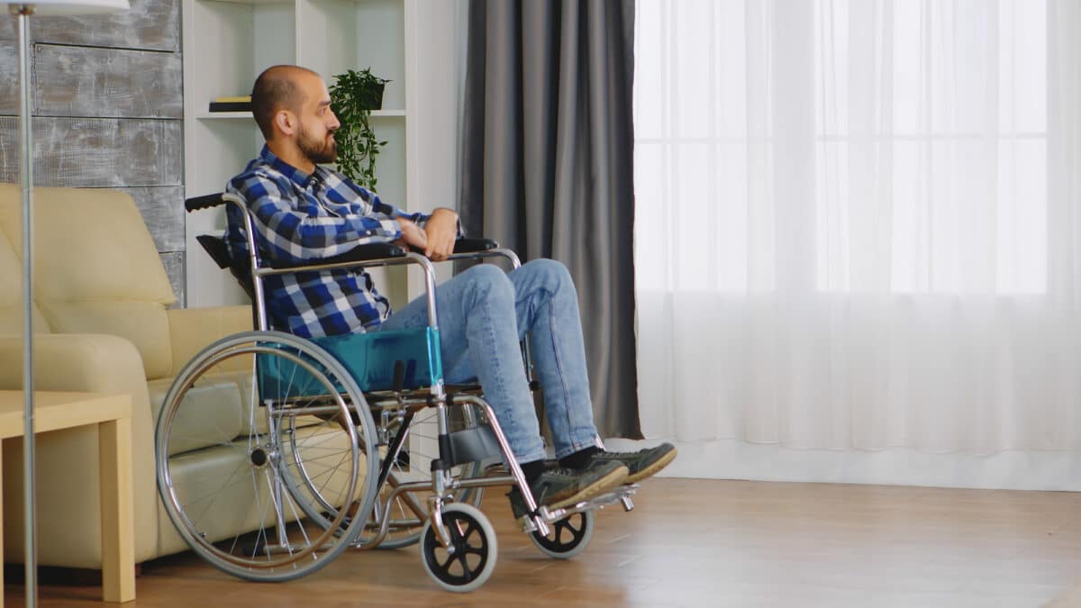 Imagem de um homem na cadeira de rodas olhando para o nada para simbolizar o auxílio-doença indeferido