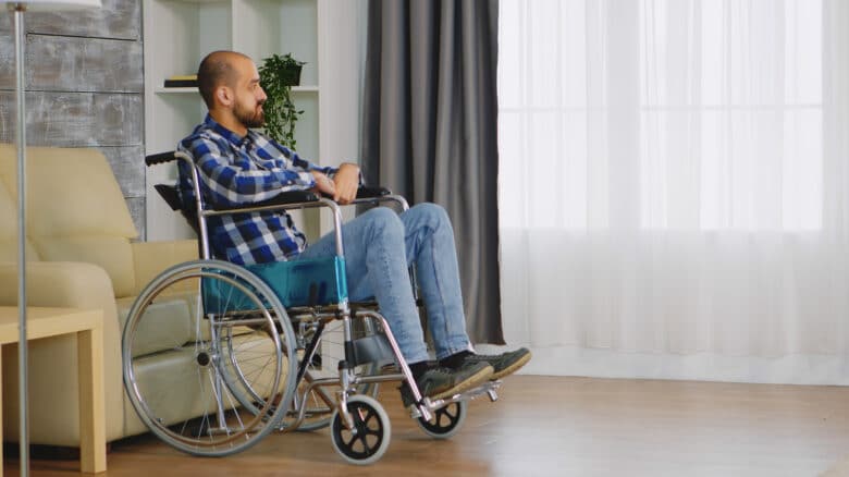 Imagem de um homem na cadeira de rodas olhando para o nada para simbolizar o auxílio-doença indeferido
